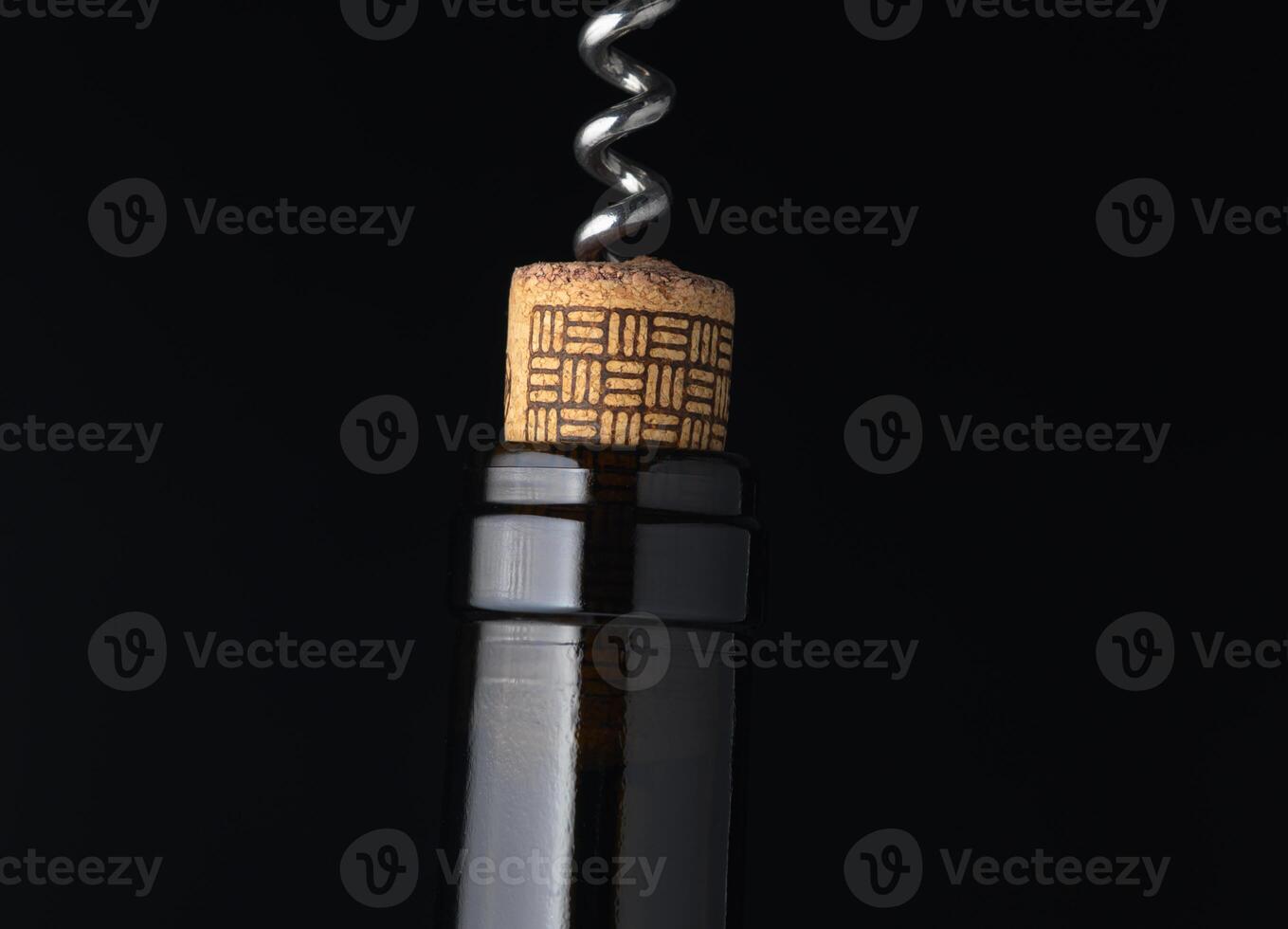Corkscrew emerges from a wine bottle, highlighting the anticipation of an elegant evening gathering in a cozy setting photo
