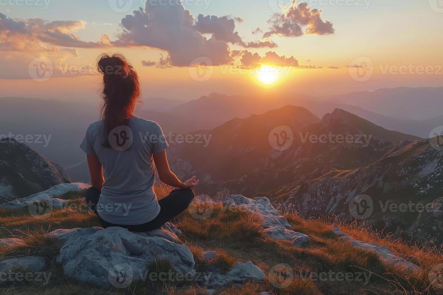 Embracing tranquility at sunset on the mountain peak in peaceful meditation. photo