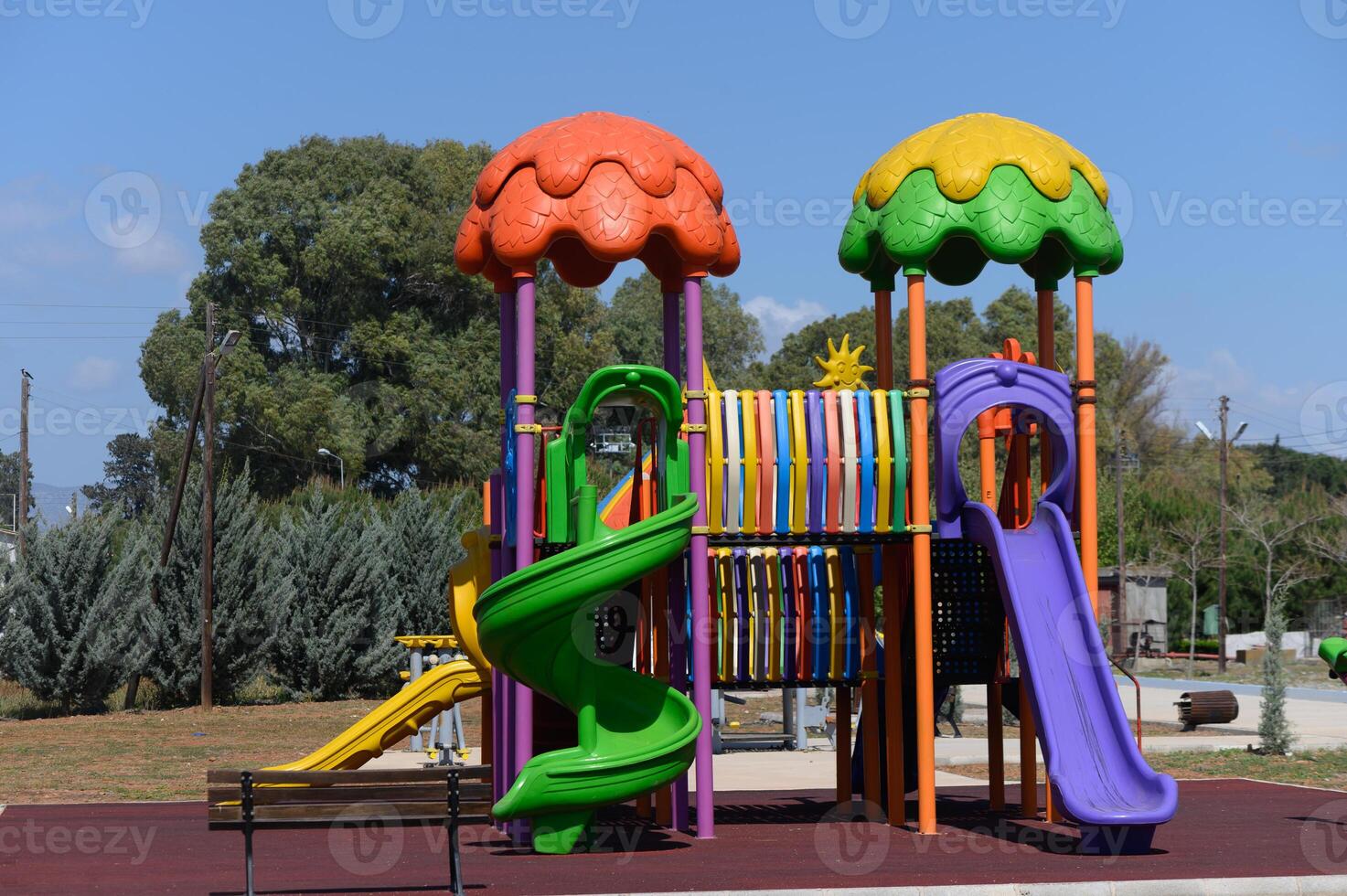 Colorful playground structures invite joyful play under a bright blue sky in a sunny park setting photo
