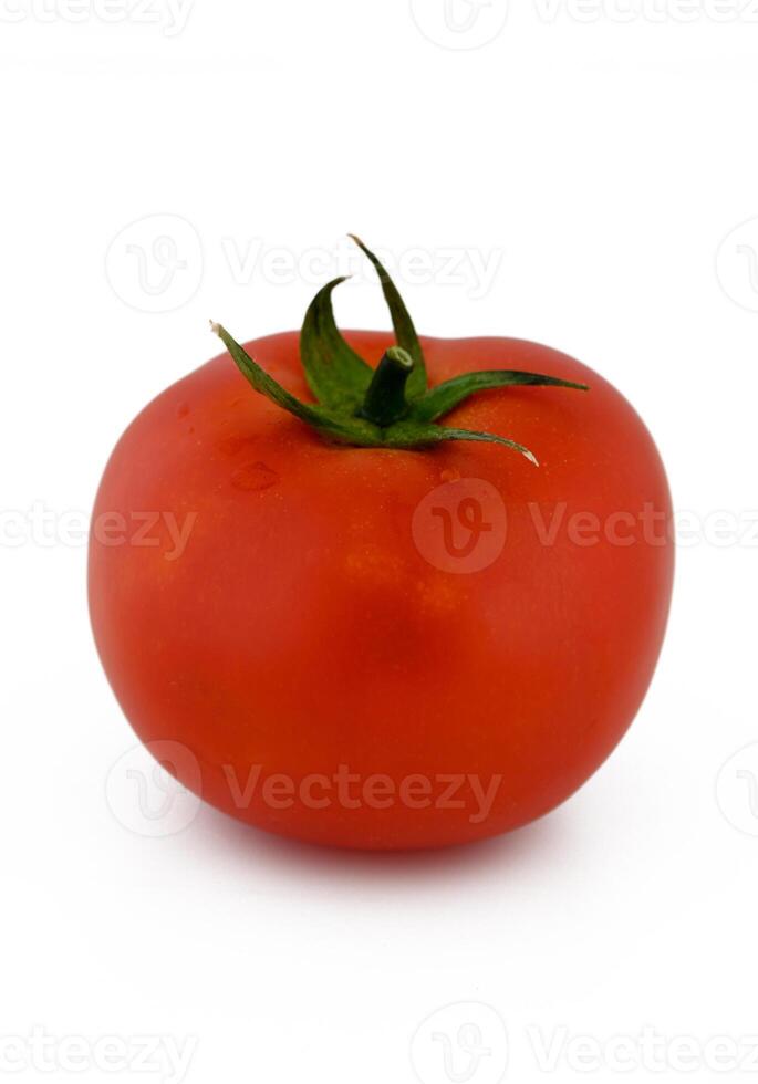 Bright red tomato glistens under soft lighting showcasing its fresh texture and vibrant color in a minimalist setting photo