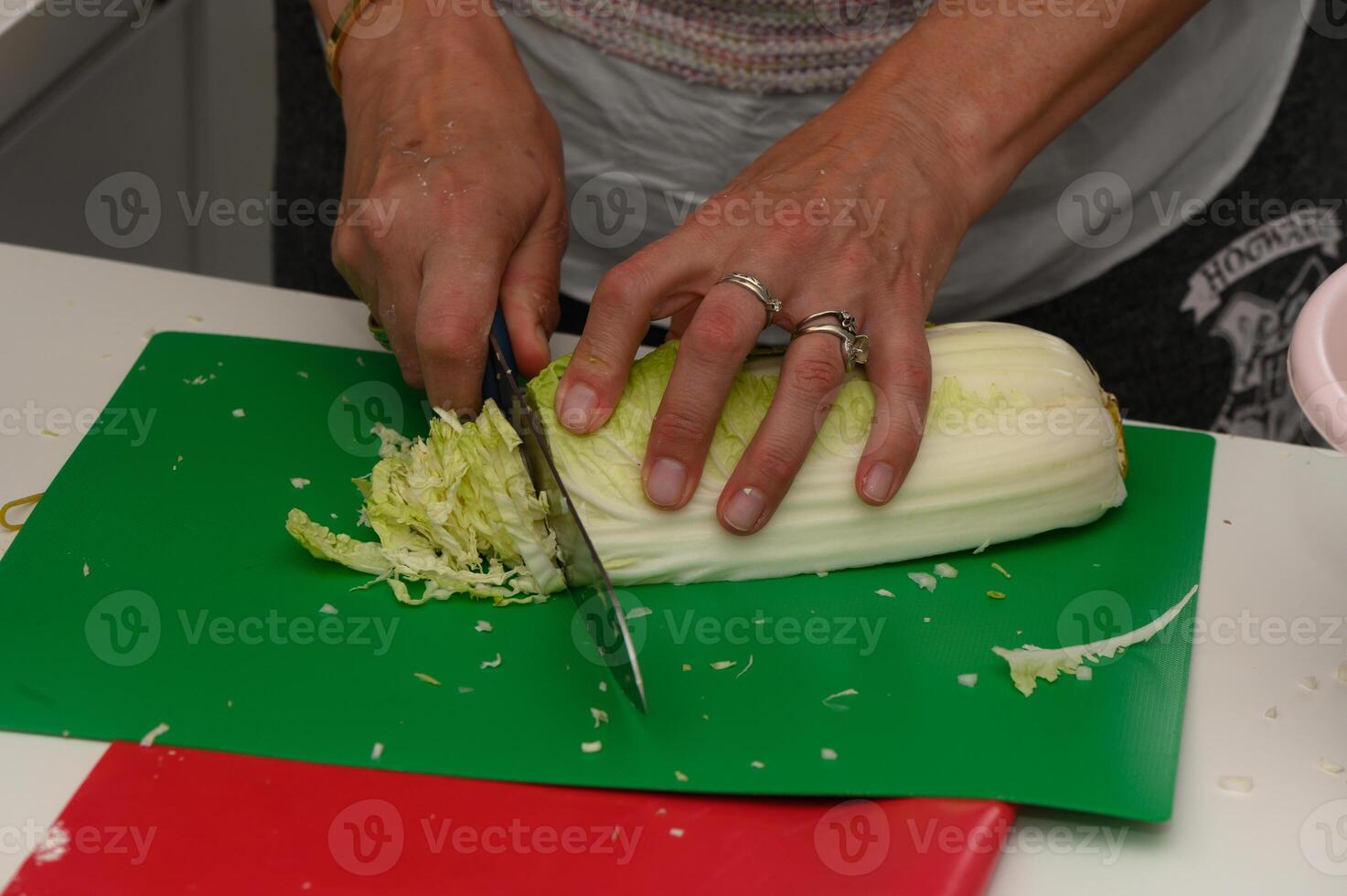 Chopping fresh cabbage for delicious spring rolls in a bright kitchen during a lively cooking session photo