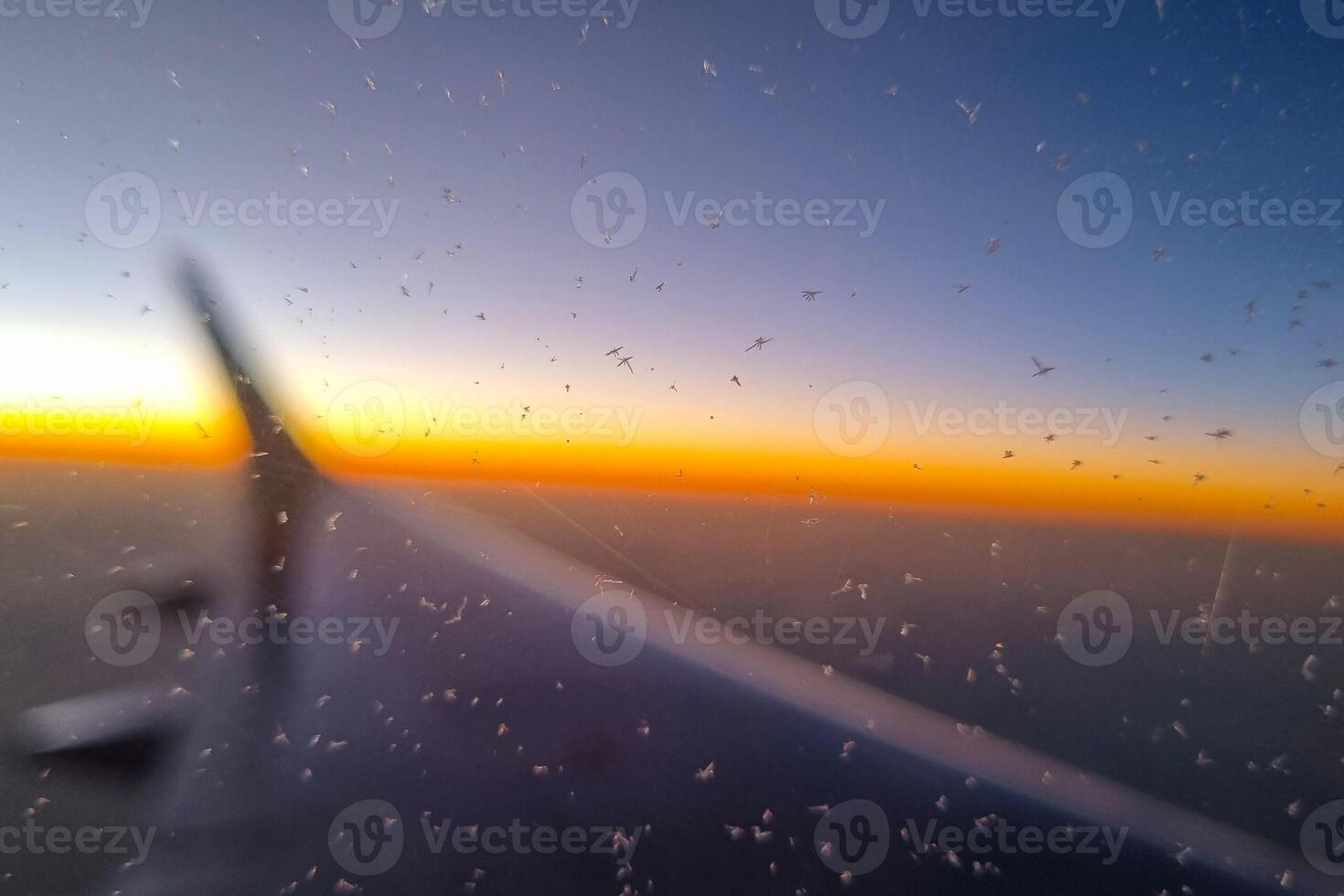 Sunrise View from Airplane Window with Frosted Glass and Wing Silhouette photo