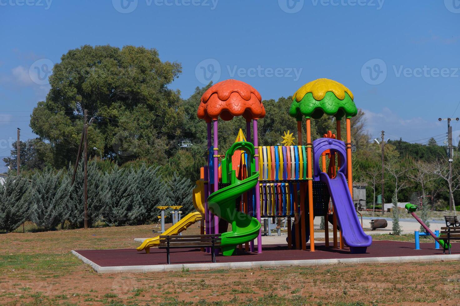 Colorful playground structure invites joyful play under a clear blue sky in a serene park setting photo