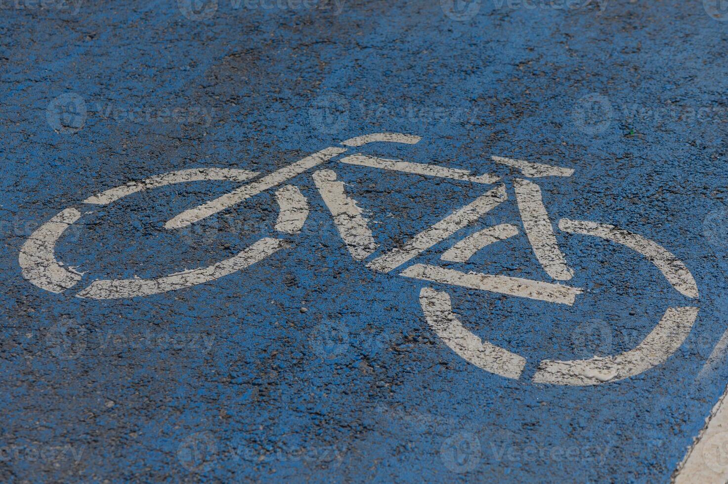 Bicycle symbol painted on a vibrant blue pavement in an urban setting promoting cycling for all photo