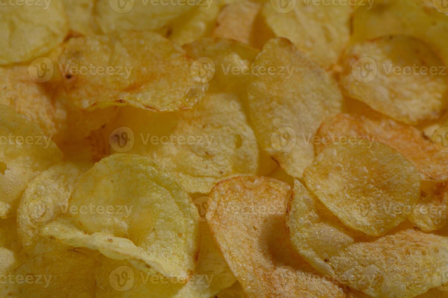 Golden and crispy potato chips piled high in a casual gathering, inviting everyone to enjoy their crunchiness at sunset photo