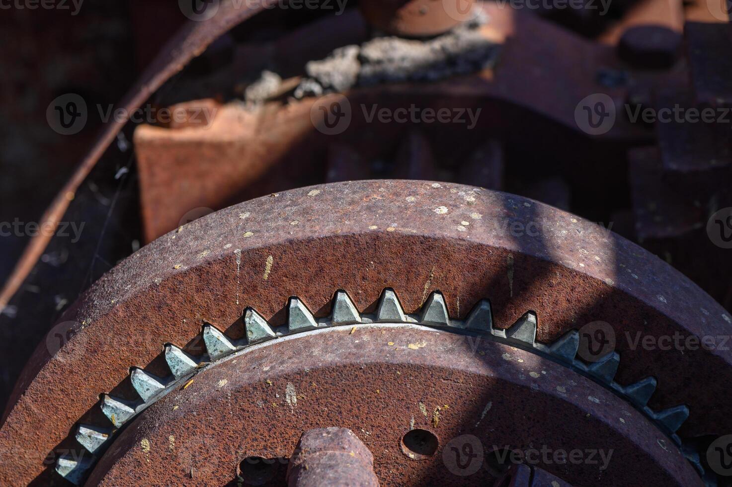 Rusty gears catching sunlight in an abandoned machinery workshop tells a story of forgotten craftsmanship photo