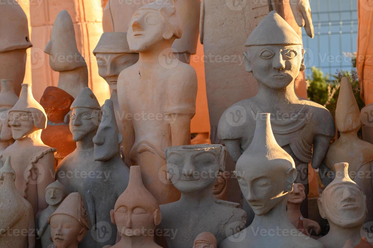 Charming collection of clay figurines depicting ancient cultures in the warm glow of sunset at a local artisan market photo