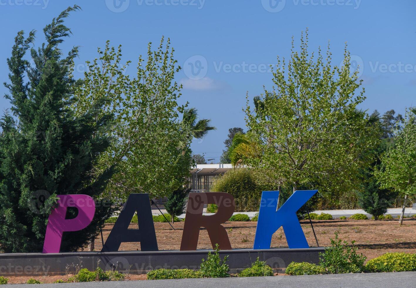 Vibrant park sign stands amidst lush greenery in bright daylight inviting visitors to explore nature's beauty photo