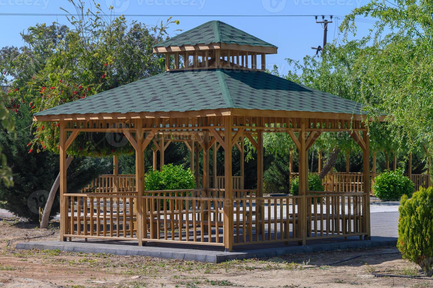 Elegant wooden gazebo invites relaxation amidst lush greenery in a tranquil garden setting photo