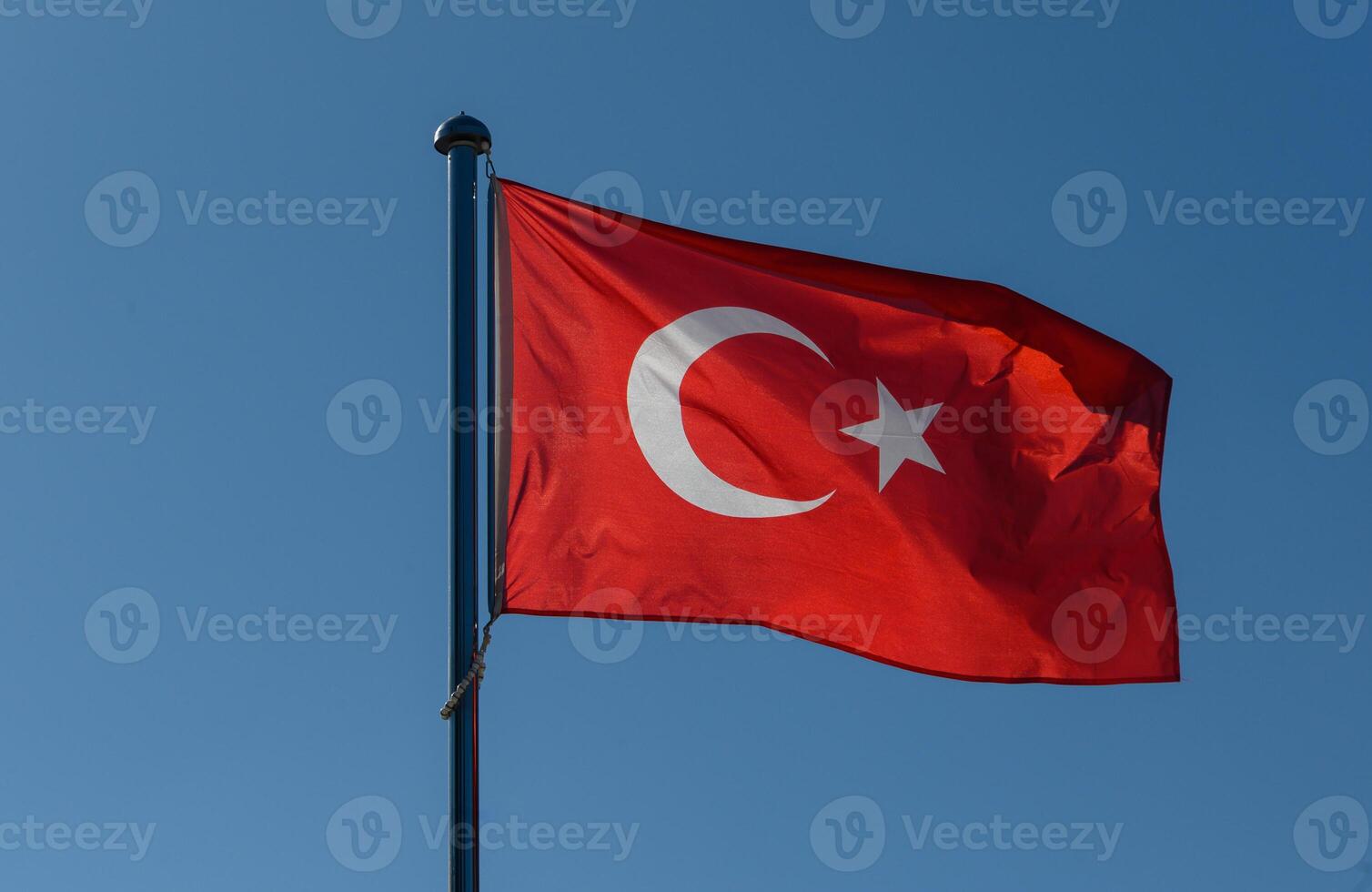Waving flag of Turkey against a clear blue sky, symbolizing national pride and unity in the heart of the country on a sunny day photo