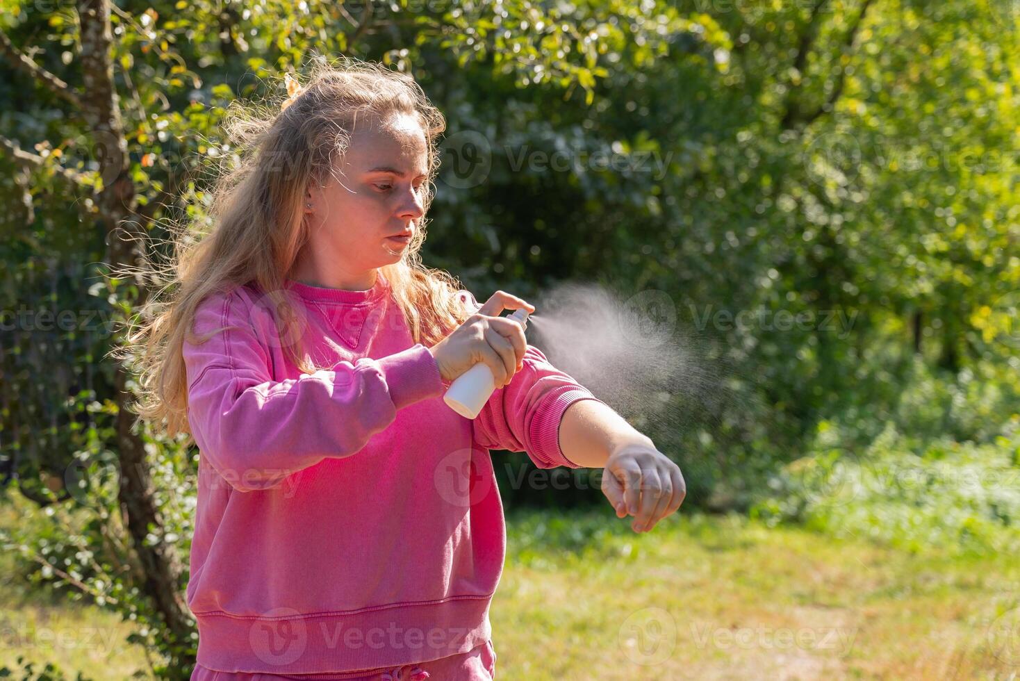 Young woman using insect sprays disease prevention. Protection against mosquito bite during summertime. Safety skin treatment outdoors photo