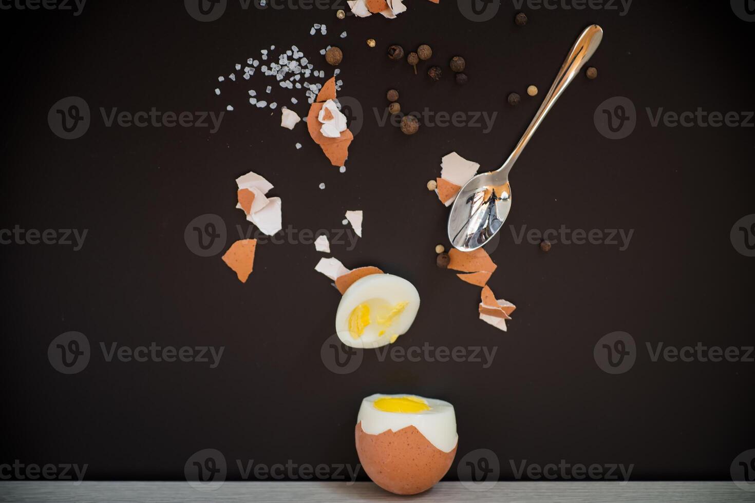 simple breakfast.Boiled egg with spices and shell on black background photo