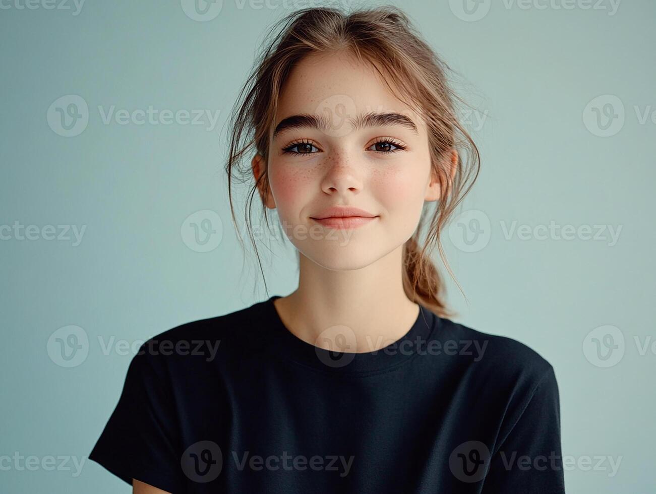 Portrait of a beautiful young girl with a black t-shirt on blue background photo
