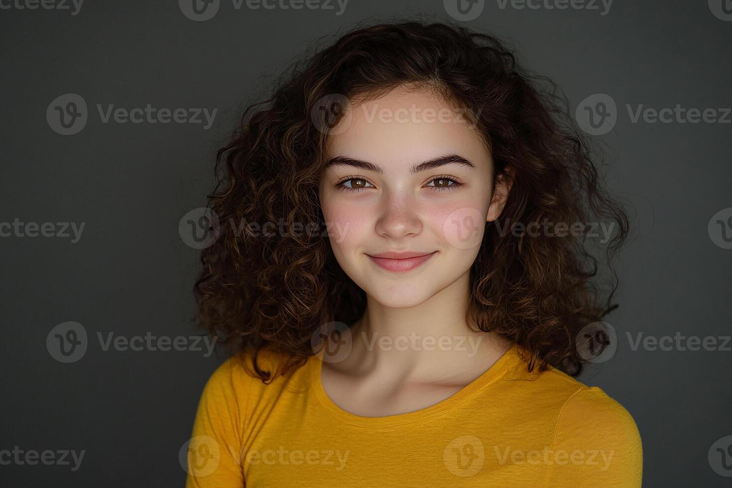 A young woman with curly hair posing for the camera photo
