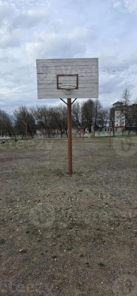 An empty basketball hoop in an outdoor court, emphasizing recreation and community sports, suitable for themes related to exercise and game culture. photo