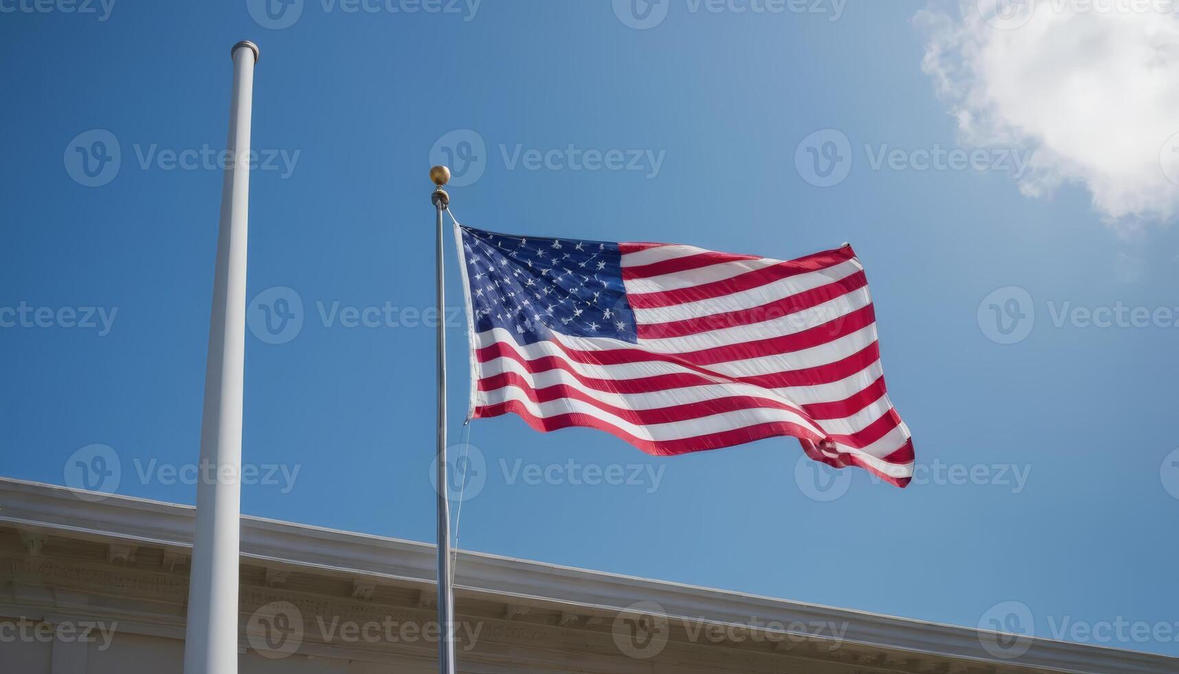 The American flag waves against a clear blue sky, symbolizing national pride and freedom with its iconic red, white, and blue colors. photo