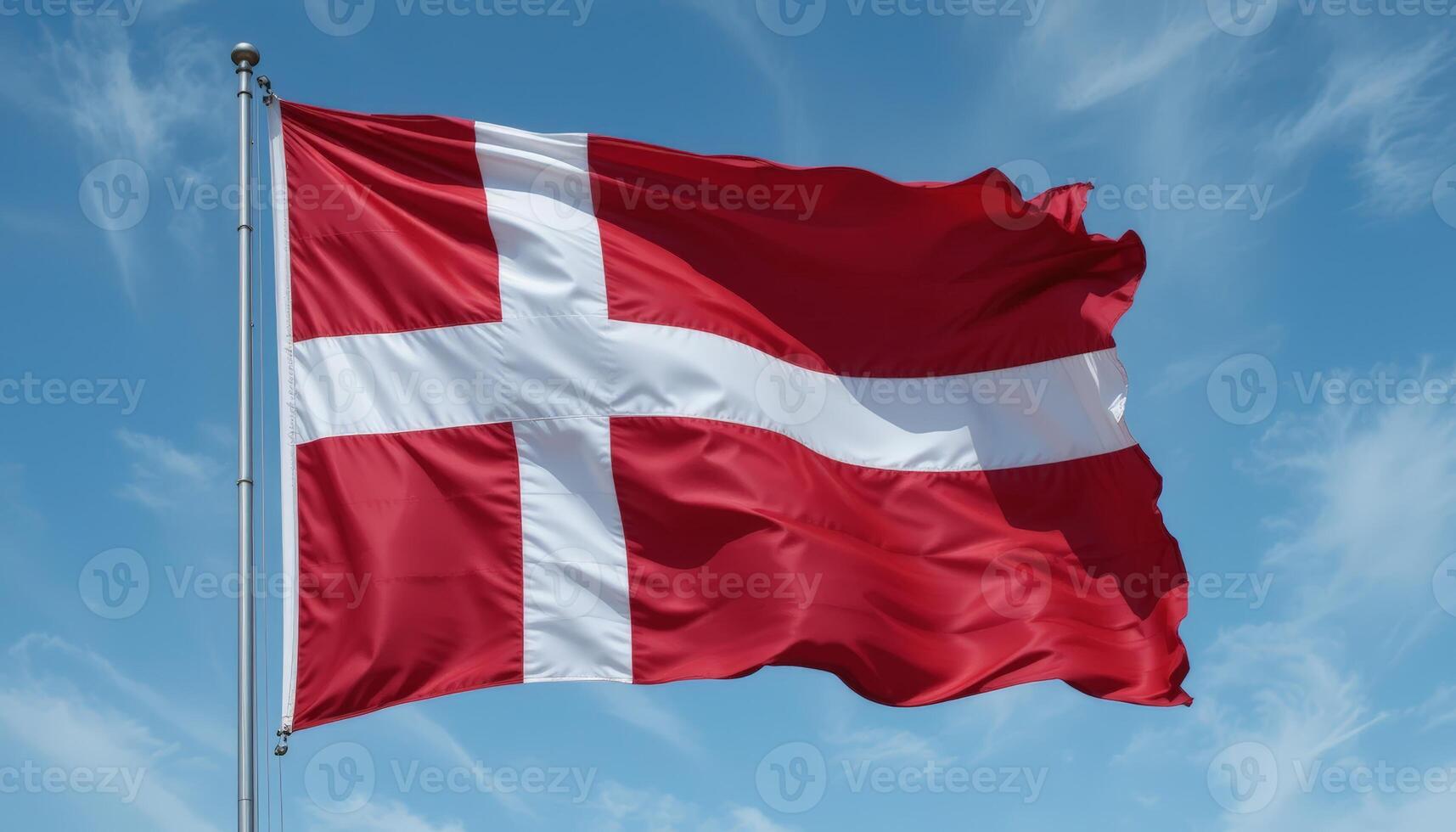 The Danish flag waves proudly against a blue sky, symbolizing national pride and cultural heritage, with its distinctive red field and white cross. photo