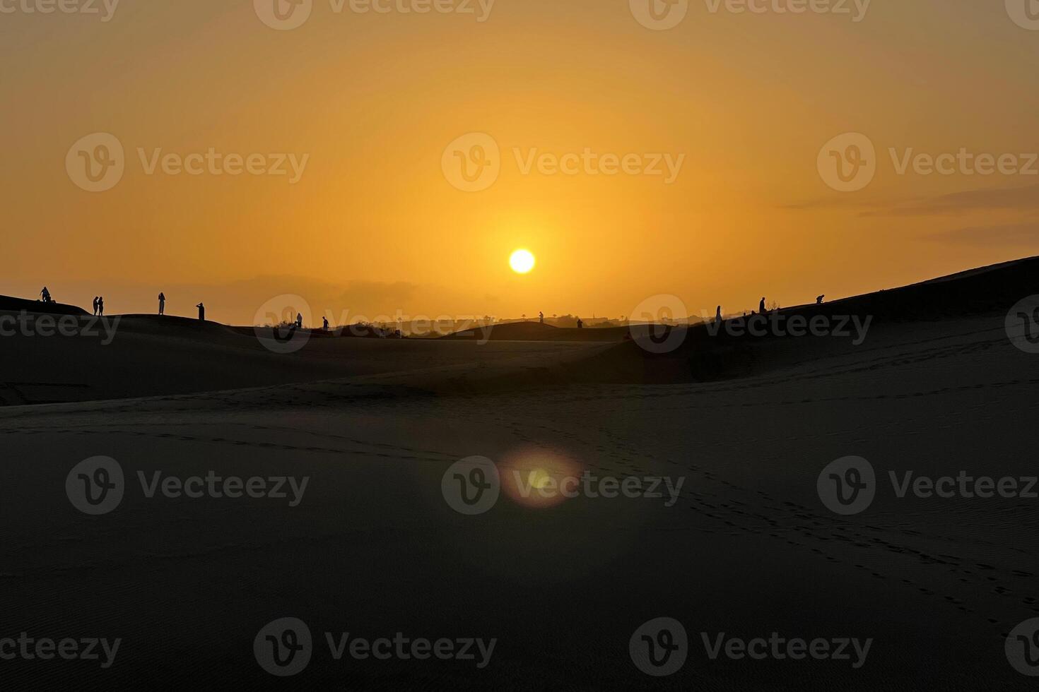 People watching a colorful sunset in a Maspalomas dune, Gran Canaria photo