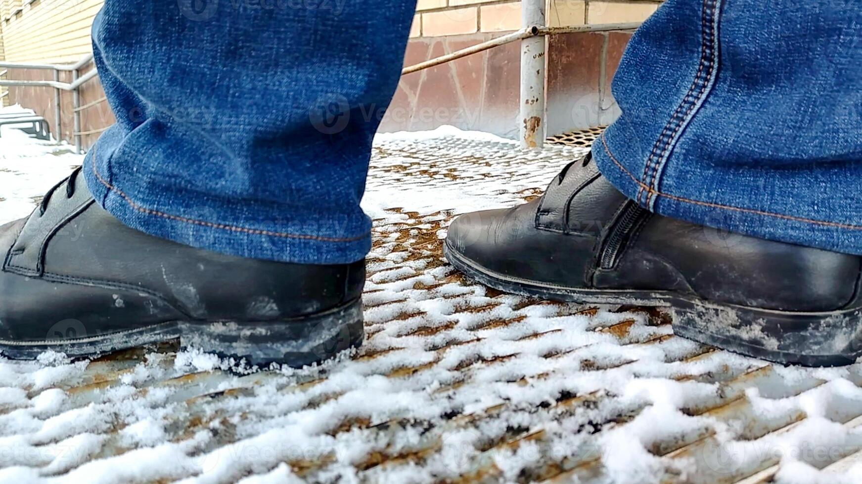 close-up of men's legs in boots and jeans standing on metal ramp. photo
