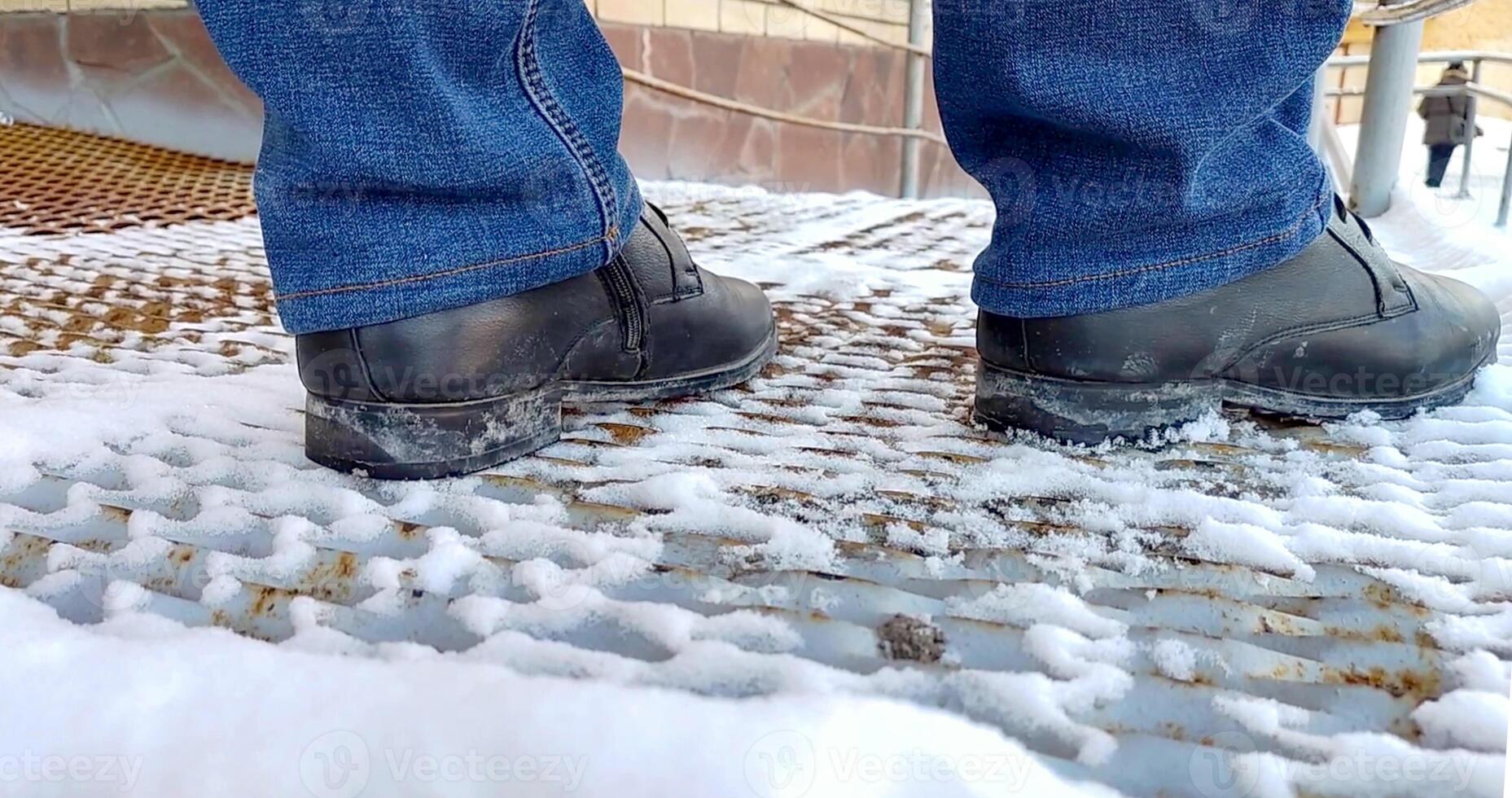 close-up of men's legs in boots and jeans standing on a metal ramp. photo