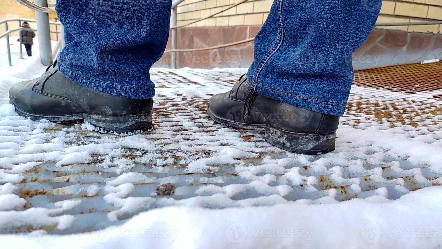 close-up of men's legs in boots and jeans standing on a metal ramp photo