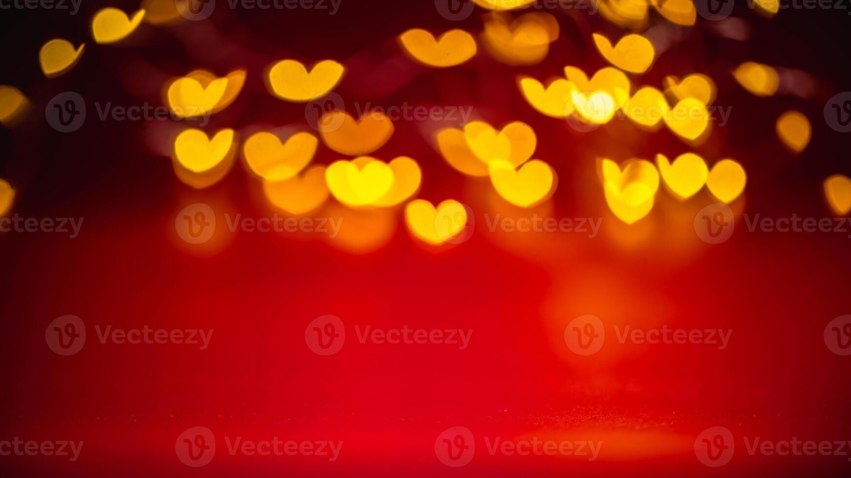 Golden heart-shaped bokeh lights create a warm, romantic atmosphere against a vibrant red backdrop, perfect for valentine's day themes and love-inspired designs photo