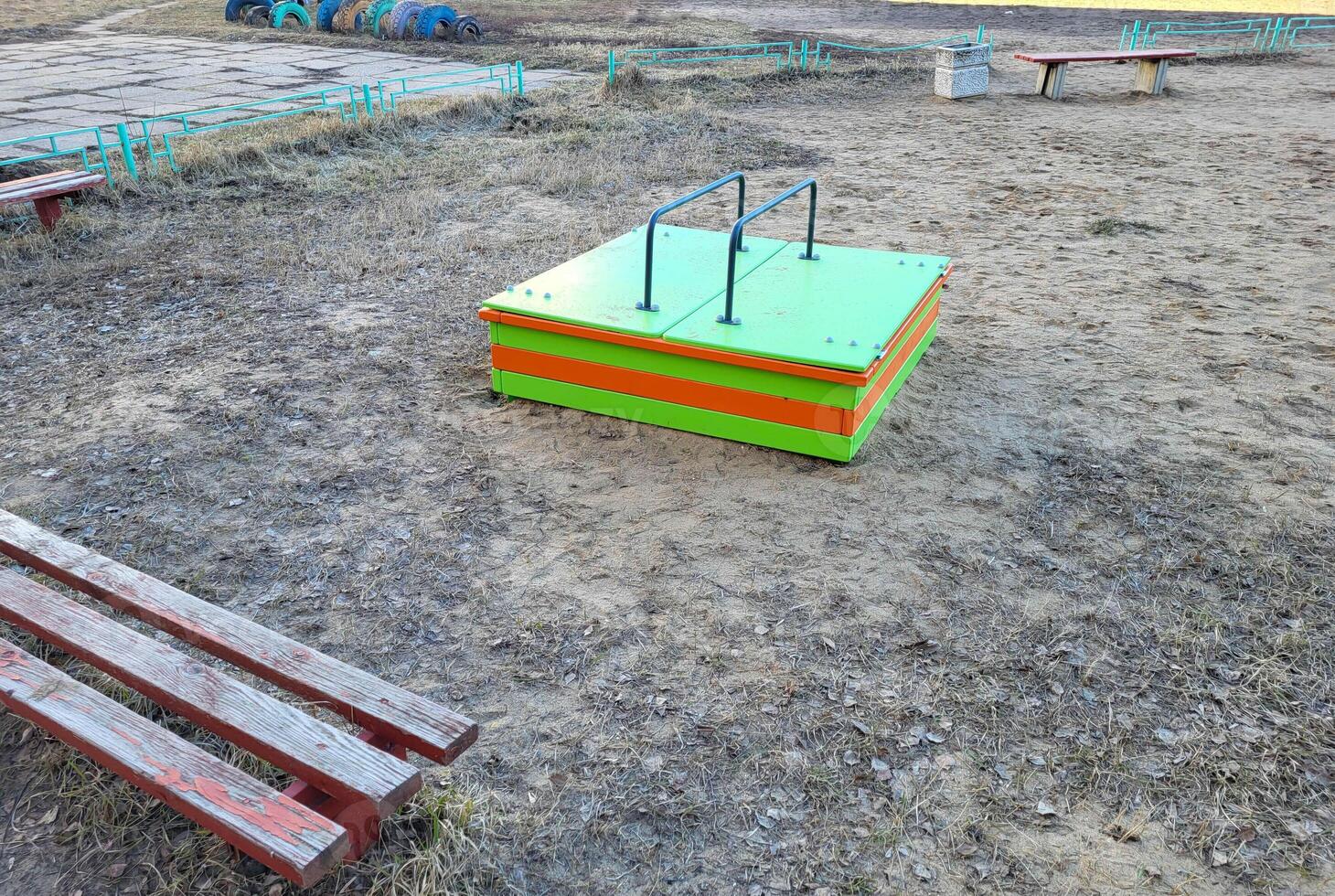 There is a green children's sandbox with a lid in the yard photo