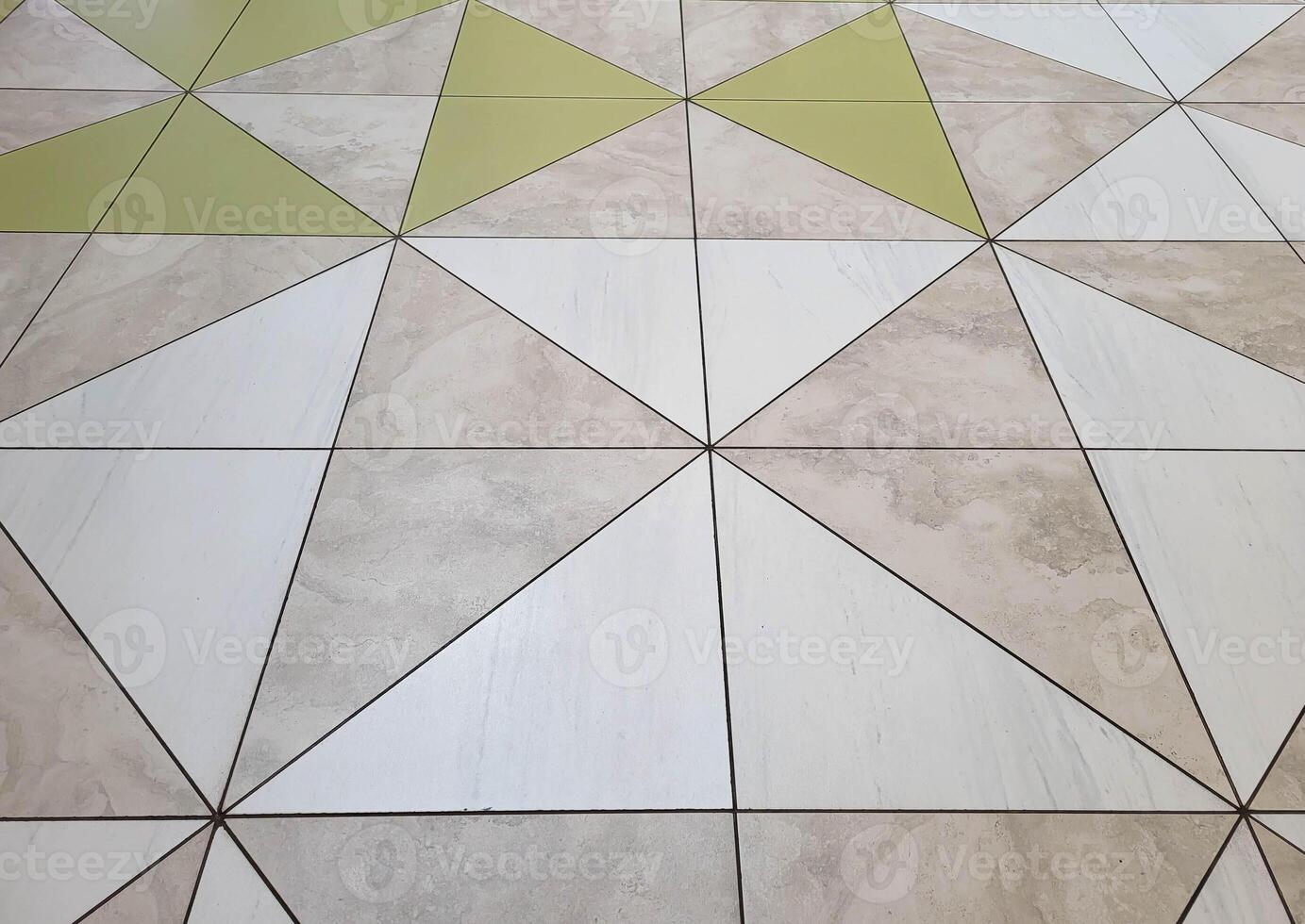 A pattern of beige and grey glossy floor tiles. photo