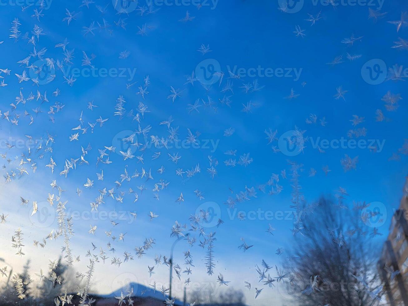 There is frost on the window against the blue sky. Icy background, frozen surface photo