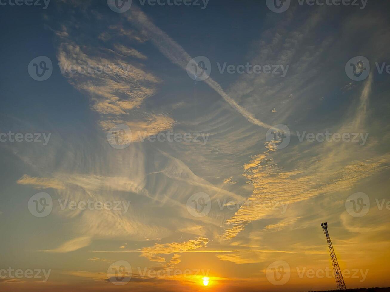 Feathery pink clouds spread out against the sunset sky. photo