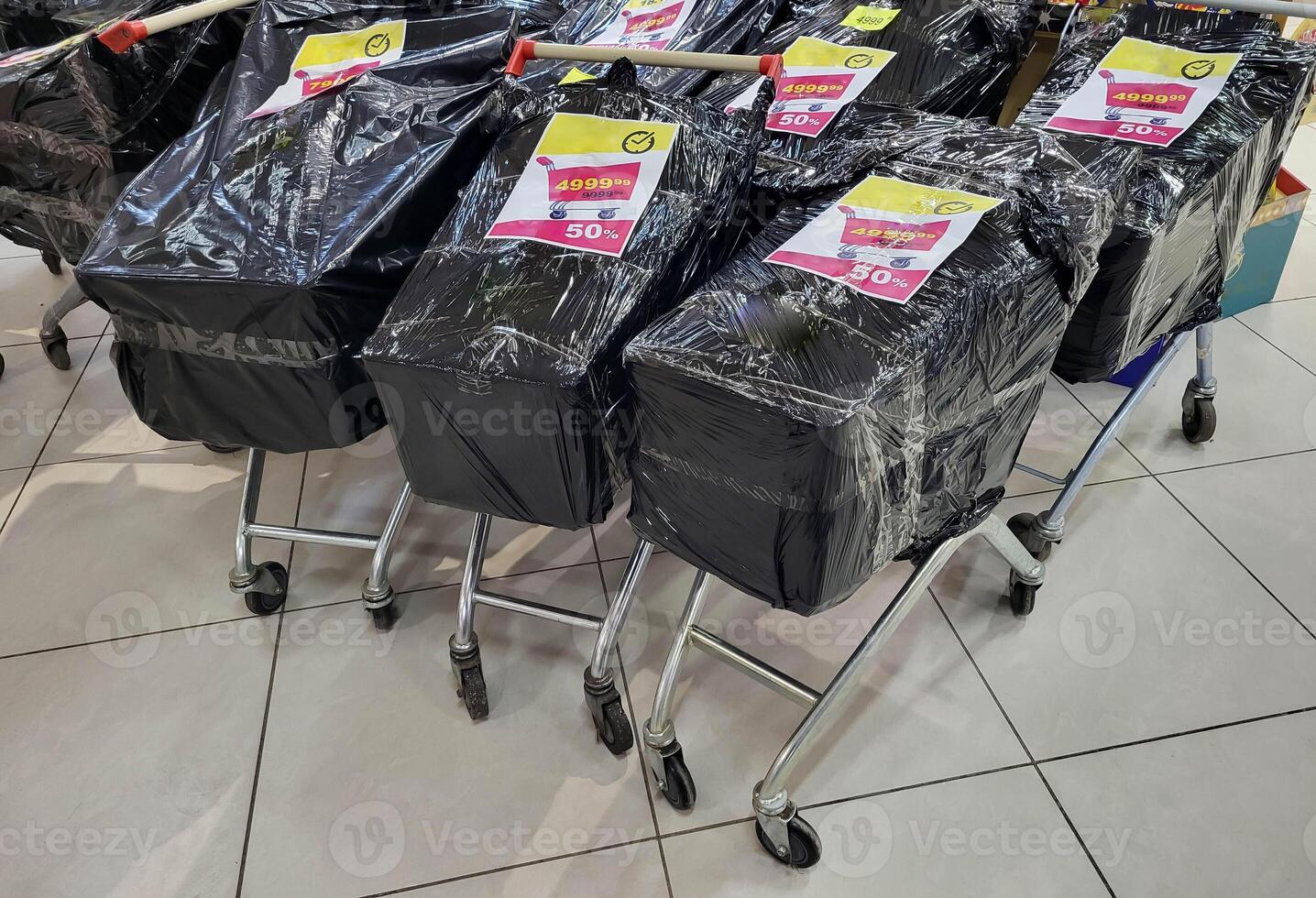 There are packed grocery carts on the floor in the store, full of holiday discount groceries photo