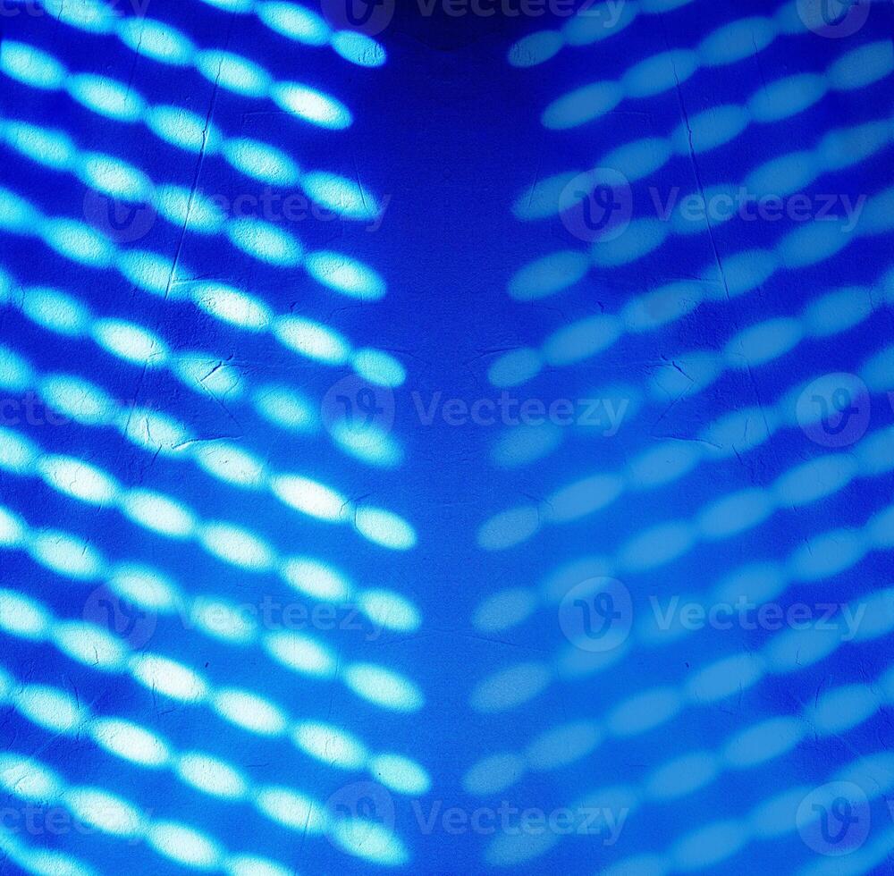 Blurred light spots, shadows from the blinds on the concrete wall, creating creating a glowing effect with a soft, futuristic texture, ideal for backgrounds and creative design. Copy space 02 photo