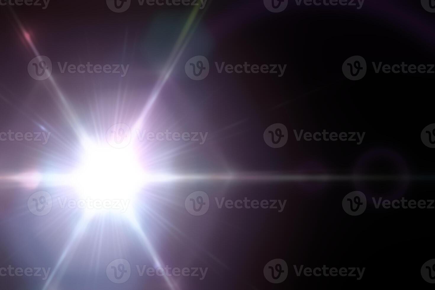 Bright light shining on a dark background with lens flare effect photo
