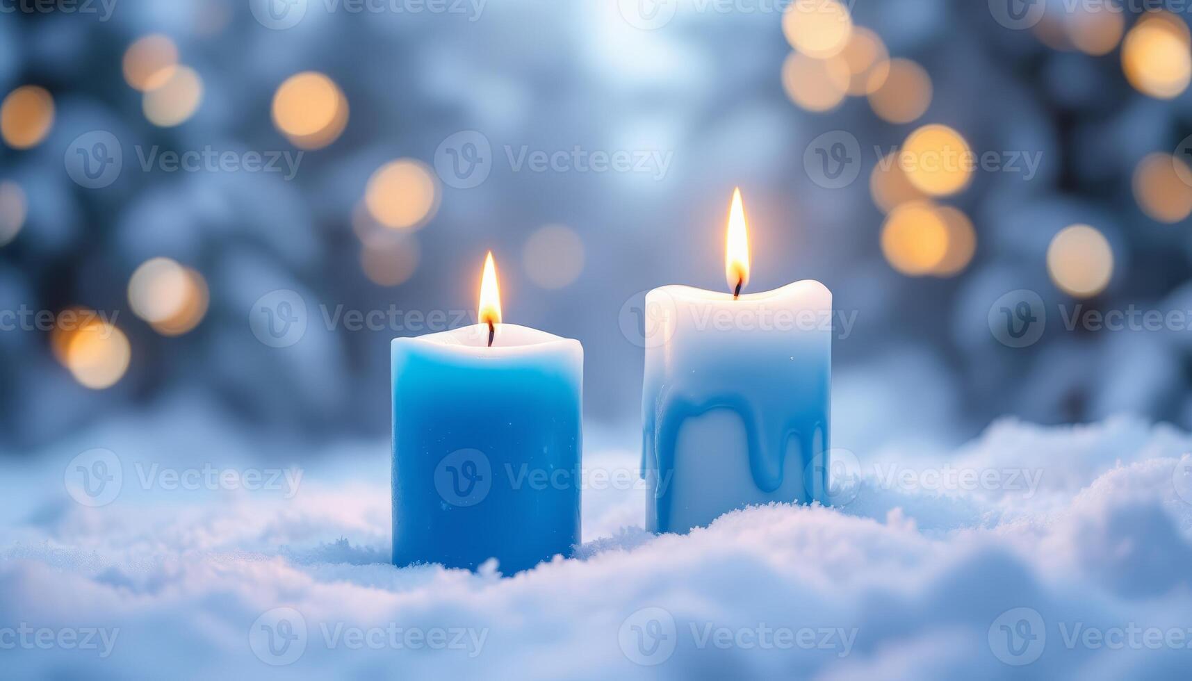 Two lit candles in the snow with bokeh light background create a winter holiday atmosphere photo