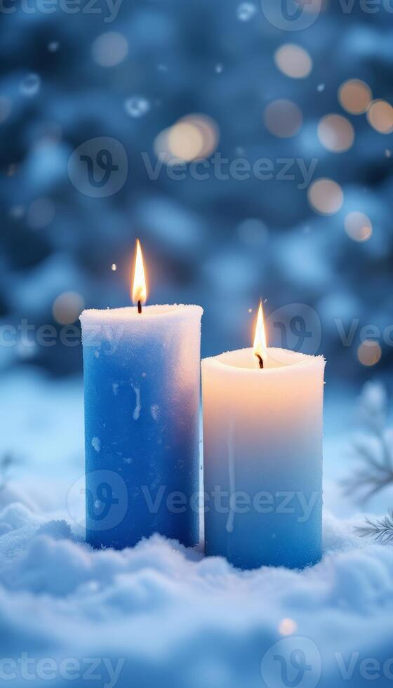 Two lit candles in snowy winter scenery glowing with a warm, soft ambiance photo