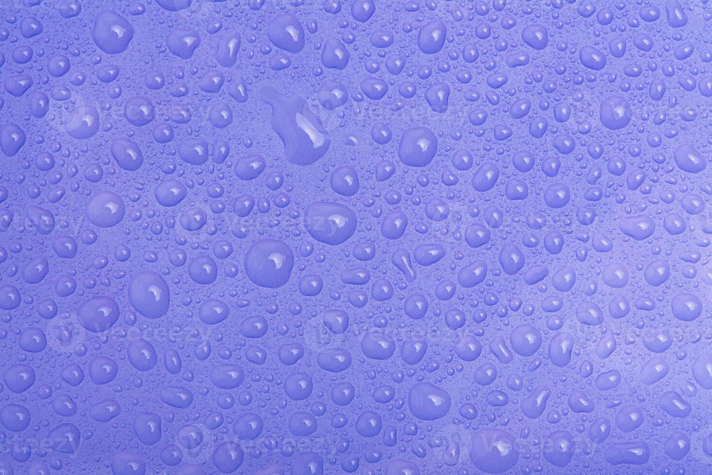 Water drops on purple plastic as a background macro photo. photo