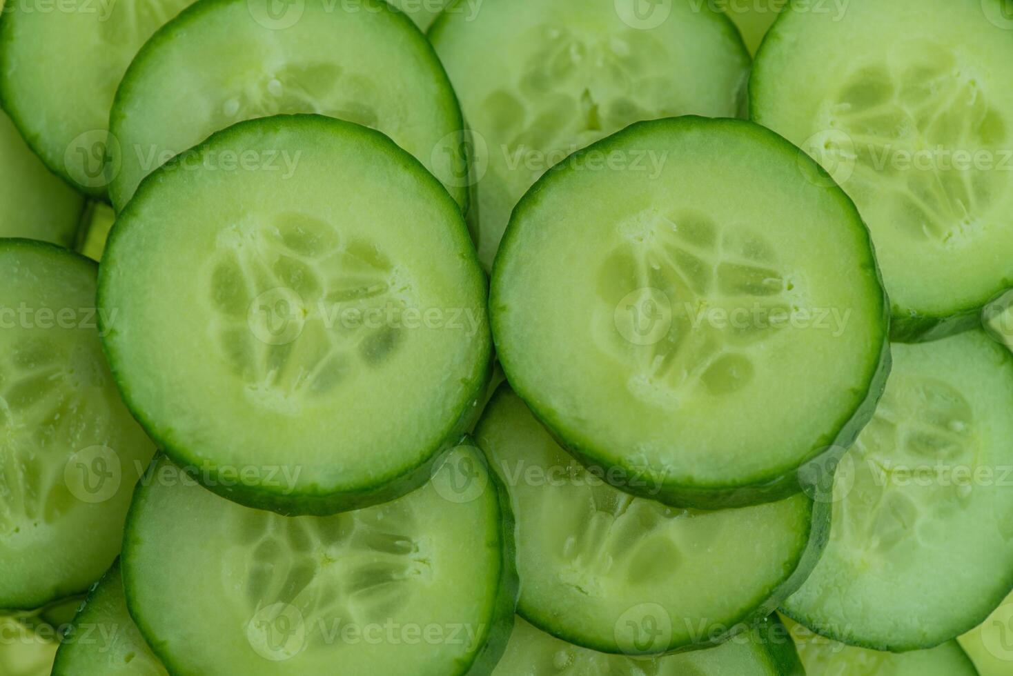Sliced fresh cucumbers as a background. photo