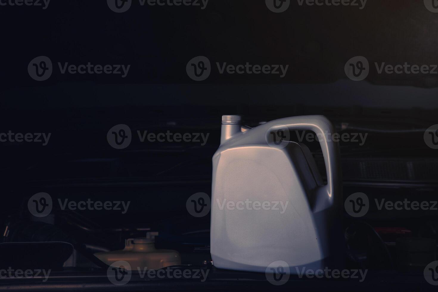Changing engine oil or fuel from an engine lubricant bottle Service industry, automobiles and engine repair technolog. photo