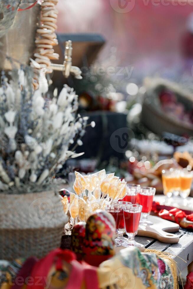 An old wooden cart, a small collection of simple treats bagels, lollipops, liqueurs photo