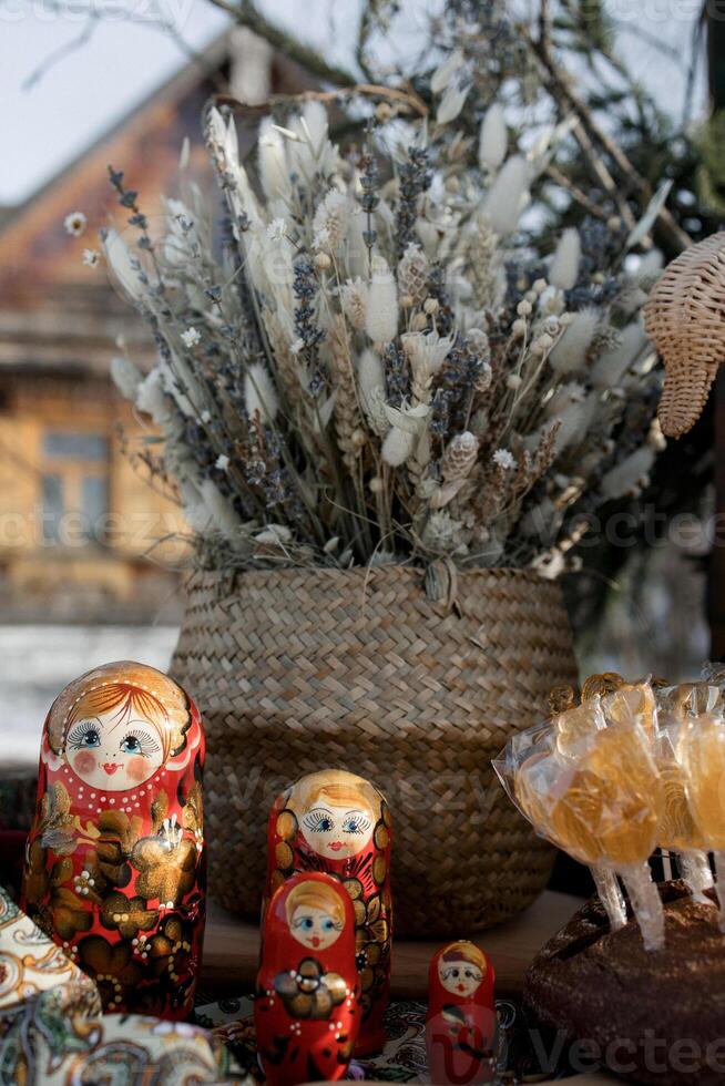 Bouquet of willow with lollipops, cockerels and nesting dolls on the street photo