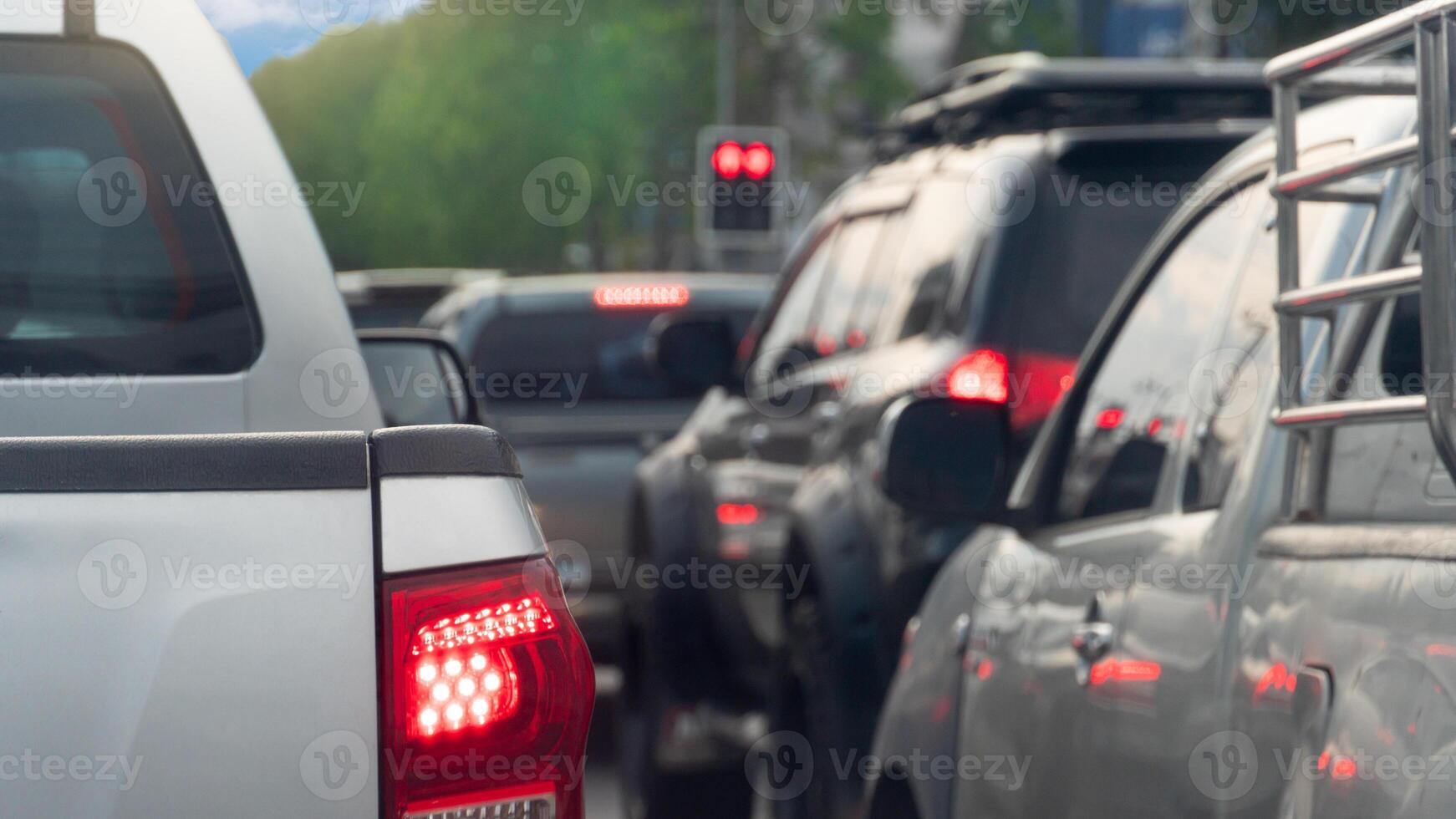 Rear side of pickup car with turn on brake light. Many cars are queuing up at a red traffic light. photo