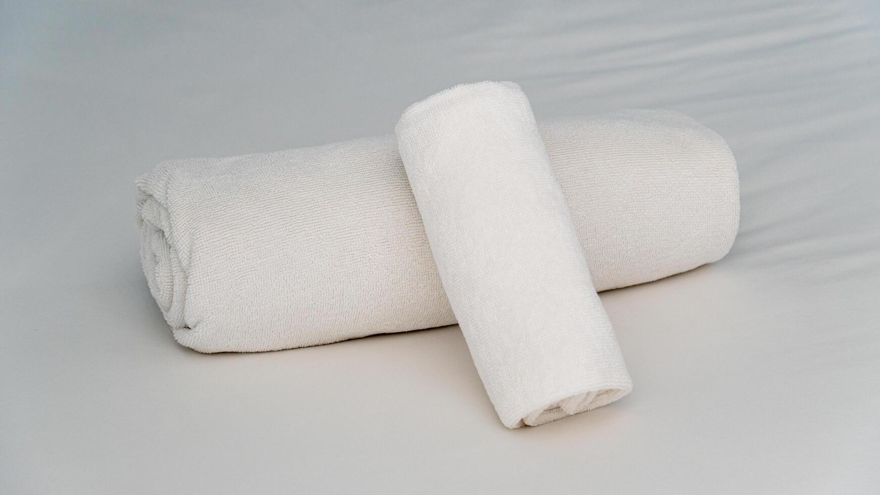 White towel rolled up on the bed. Beautiful layout for a resort welcome. photo