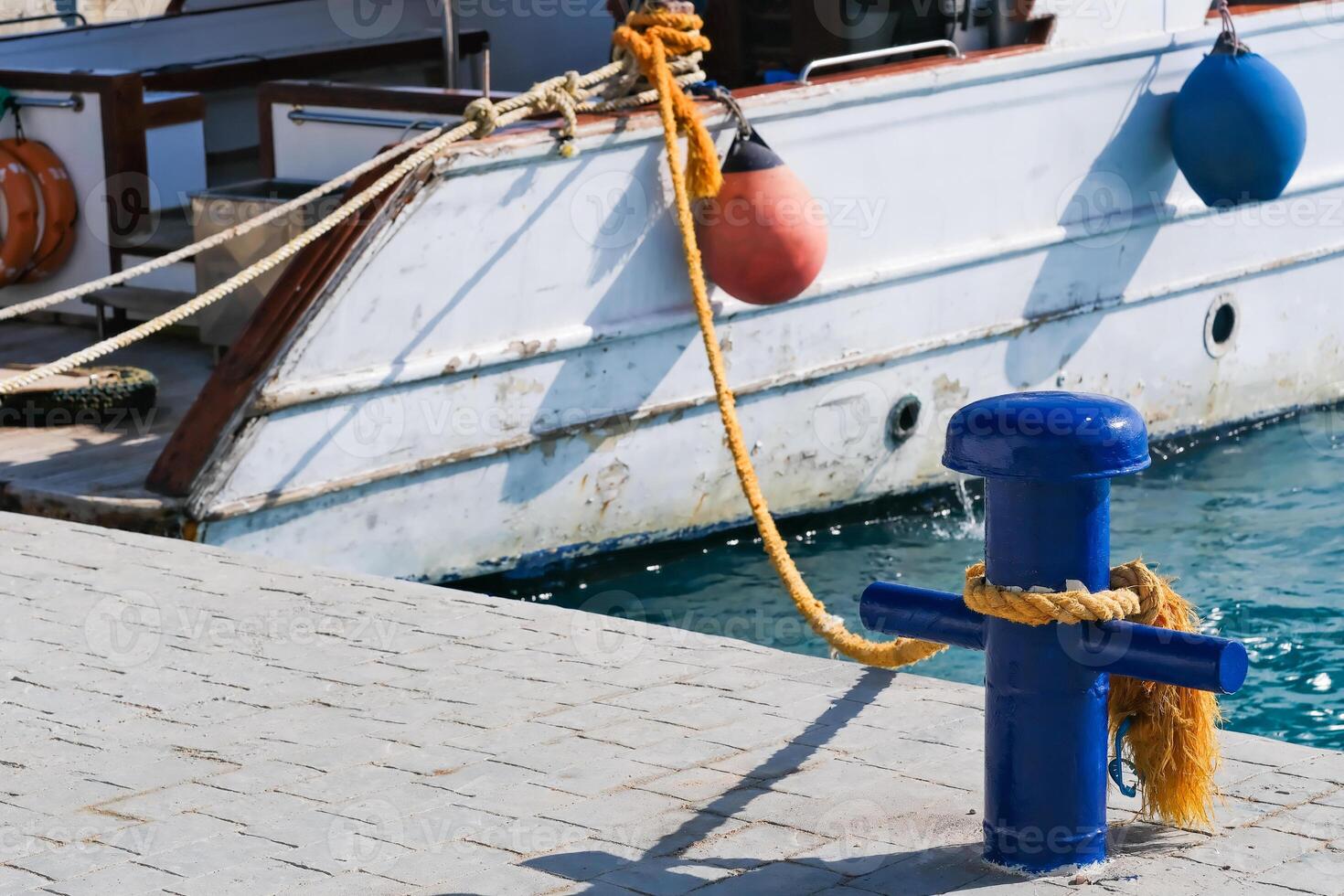 A blue and yellow buoy is tied to a boat photo