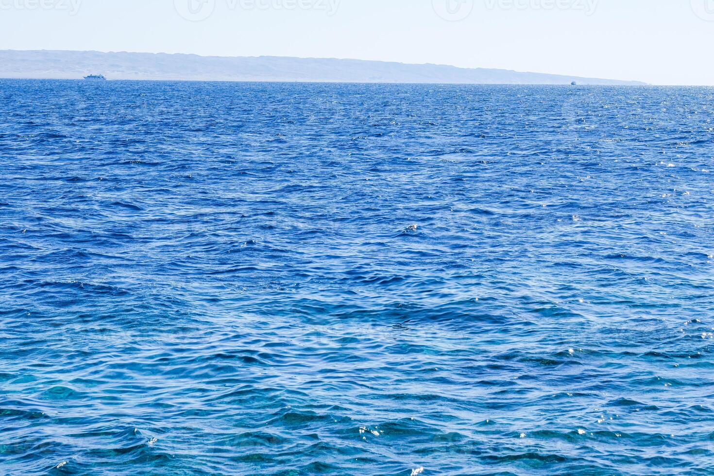 The ocean is calm and blue, with no visible waves photo
