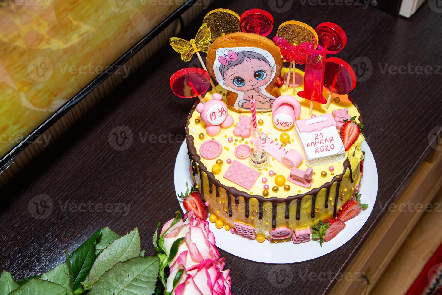 A cake with a baby doll on top and pink frosting photo