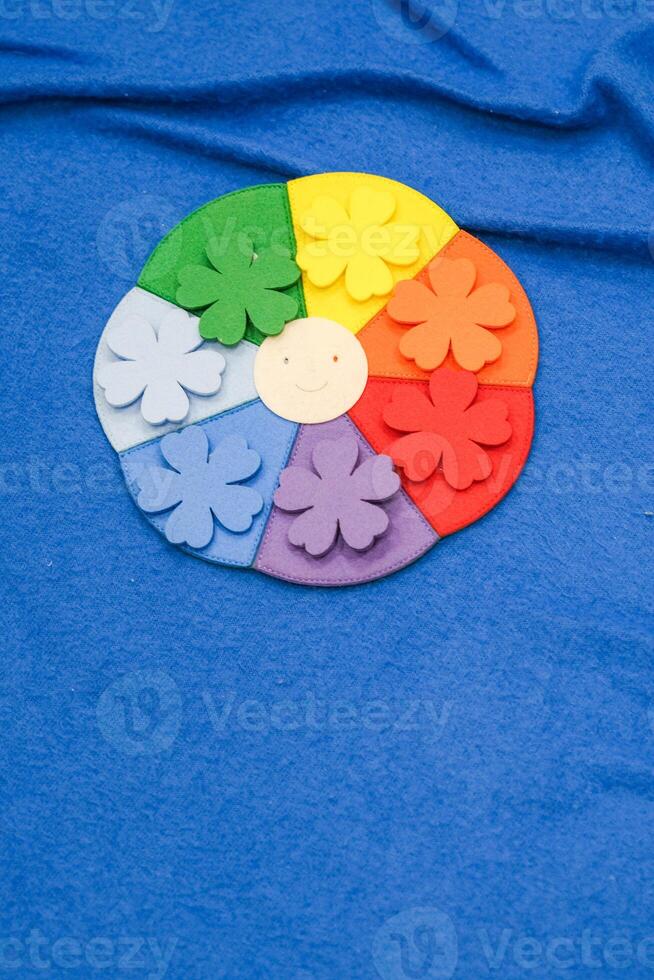 A colorful flower with a smiling face is on a blue background photo