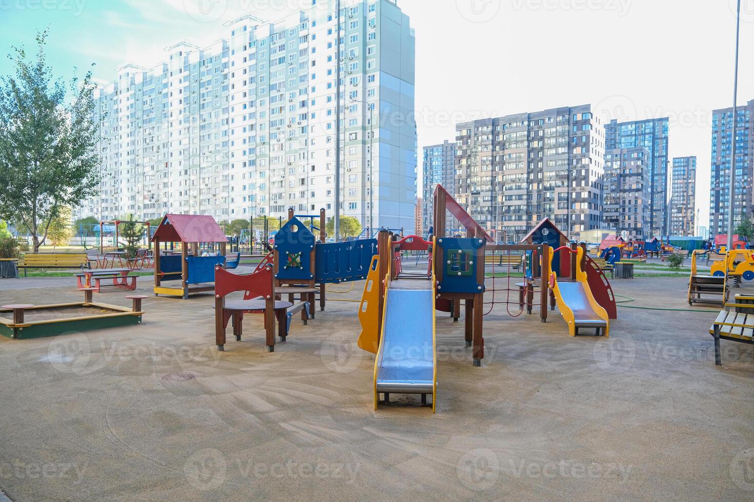 A playground with a lot of play equipment including a slide and a swing photo