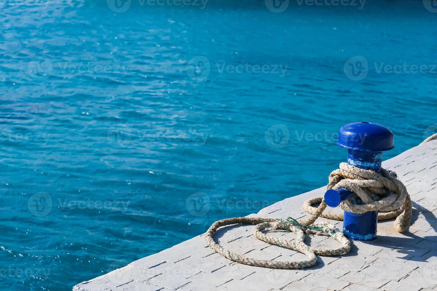 A blue buoy sits on a dock in the ocean photo