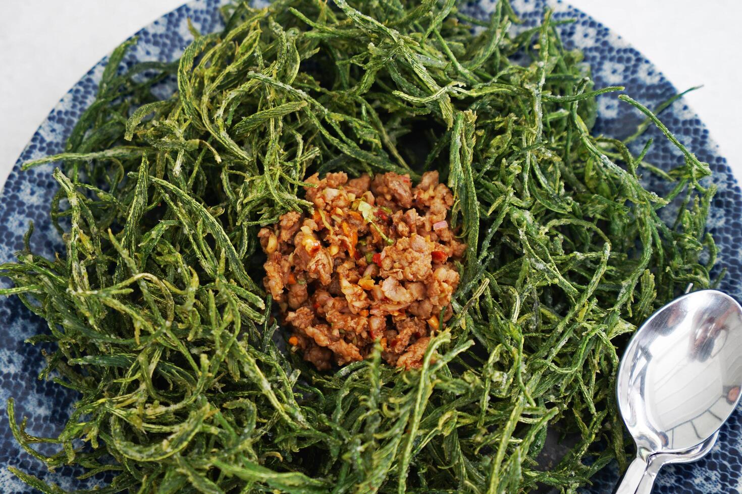 Close up battered and deep fried Acacia Pennata leaf Climbing Wattle vegetable served with stir fry minced pork with chili photo