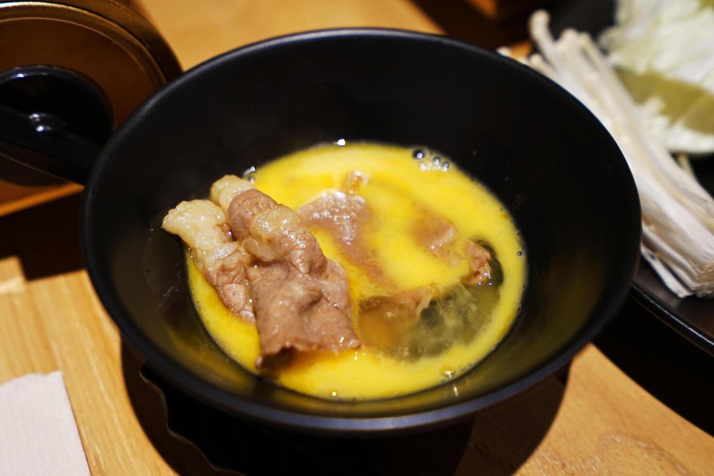 Close up Sliced Wagyu beef and pork, raw egg and dipping sauce- Sukiyaki Japanese hot pot photo